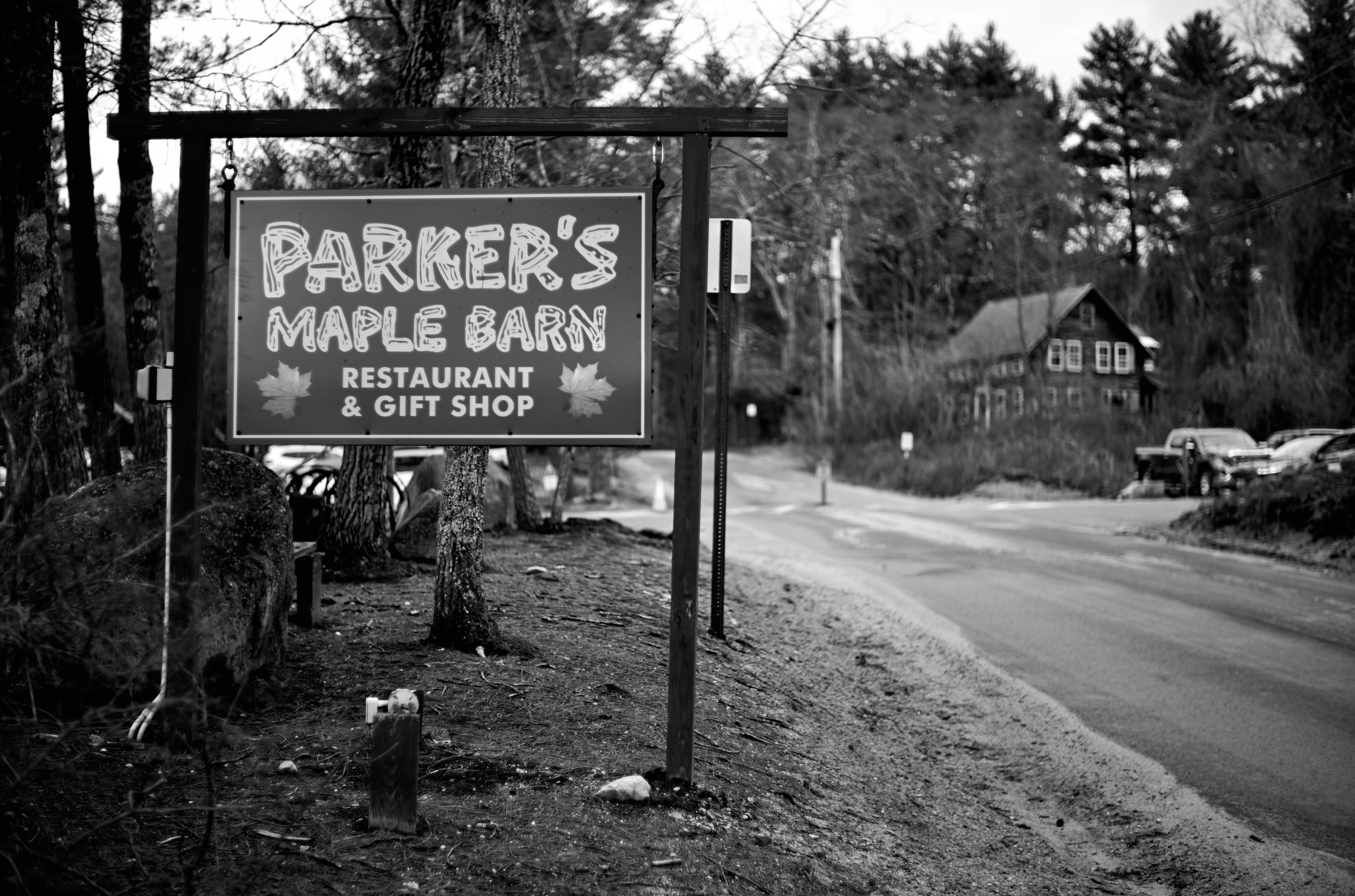 Parker's Maple Barn sign along a quiet road, the restaurant visible in the distance