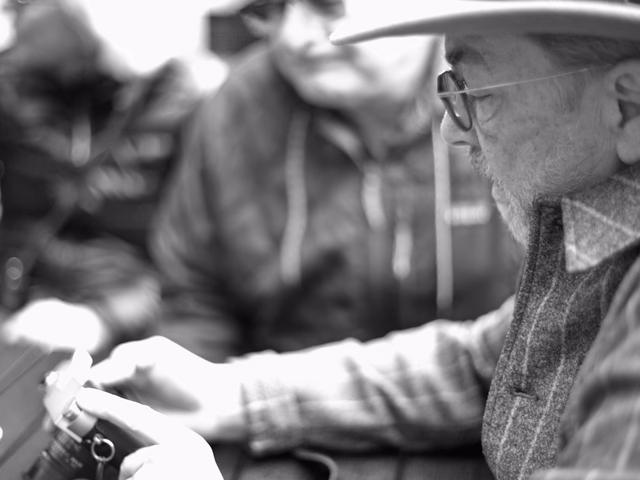 Thorsten Overgaard at the table at Elegy Coffee, adjusting a participant's camera before the morning walk