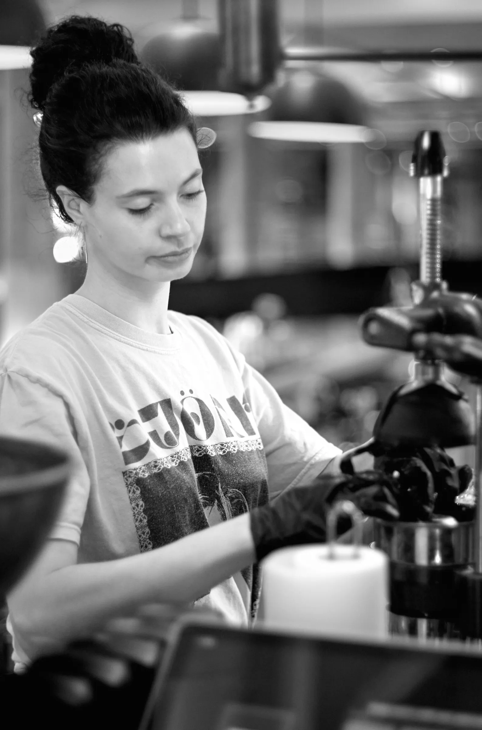 Barista at an espresso machine, in soft available light