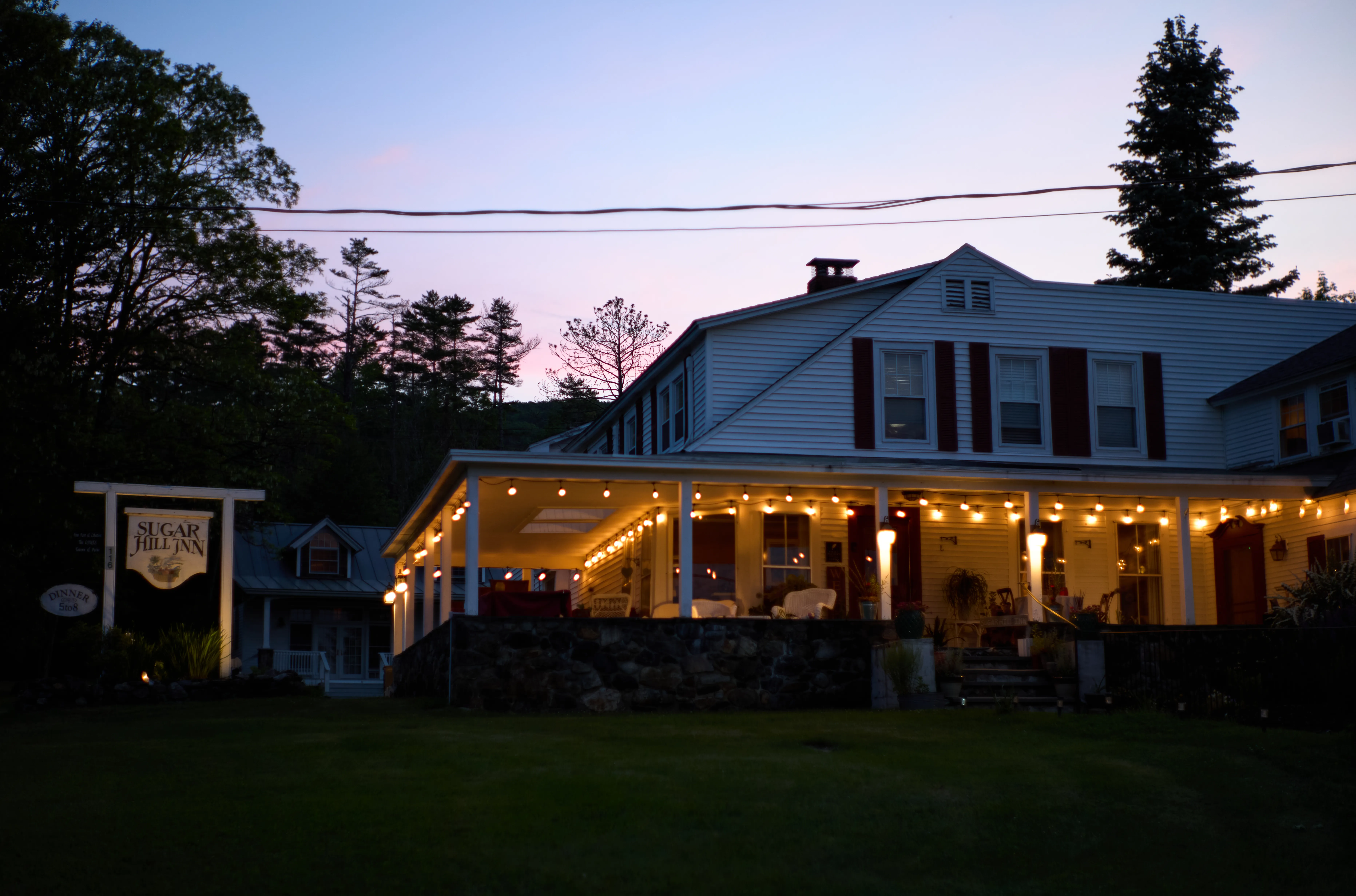 Sugar Hill Inn at night, string lights across the full length of the porch