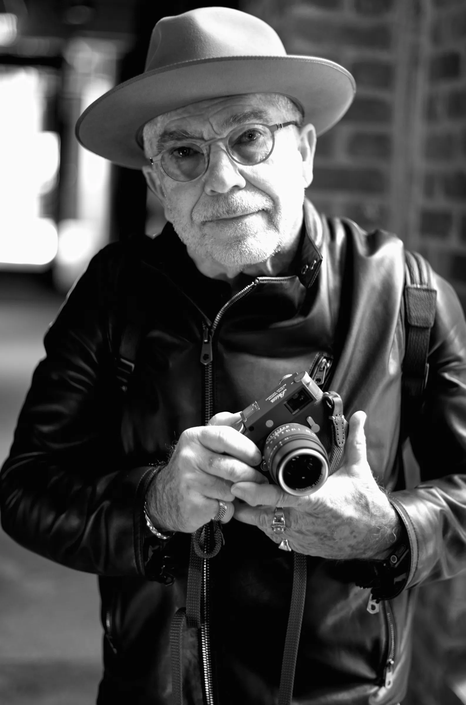 Dan Combs, workshop participant, standing near a large window holding a Leica, soft directional light