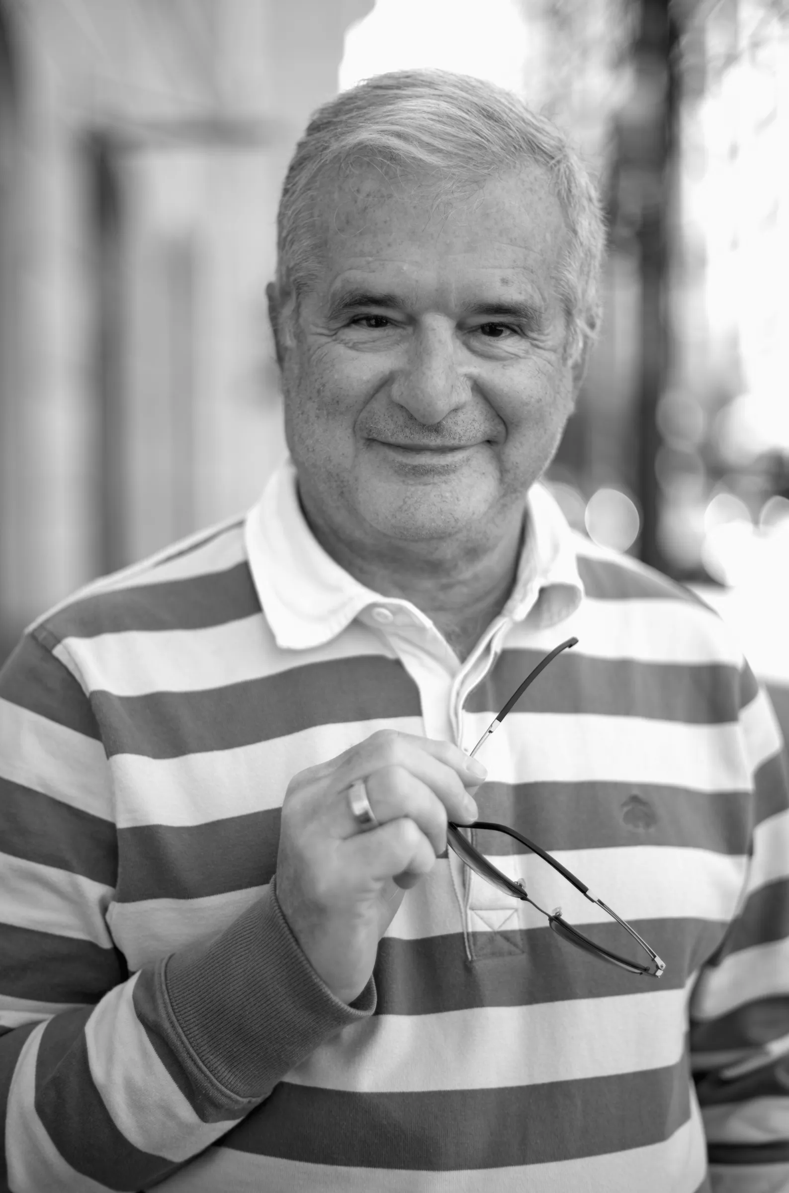 Tullio Emanuele, workshop participant, holding his glasses, smiling, outdoor portrait light